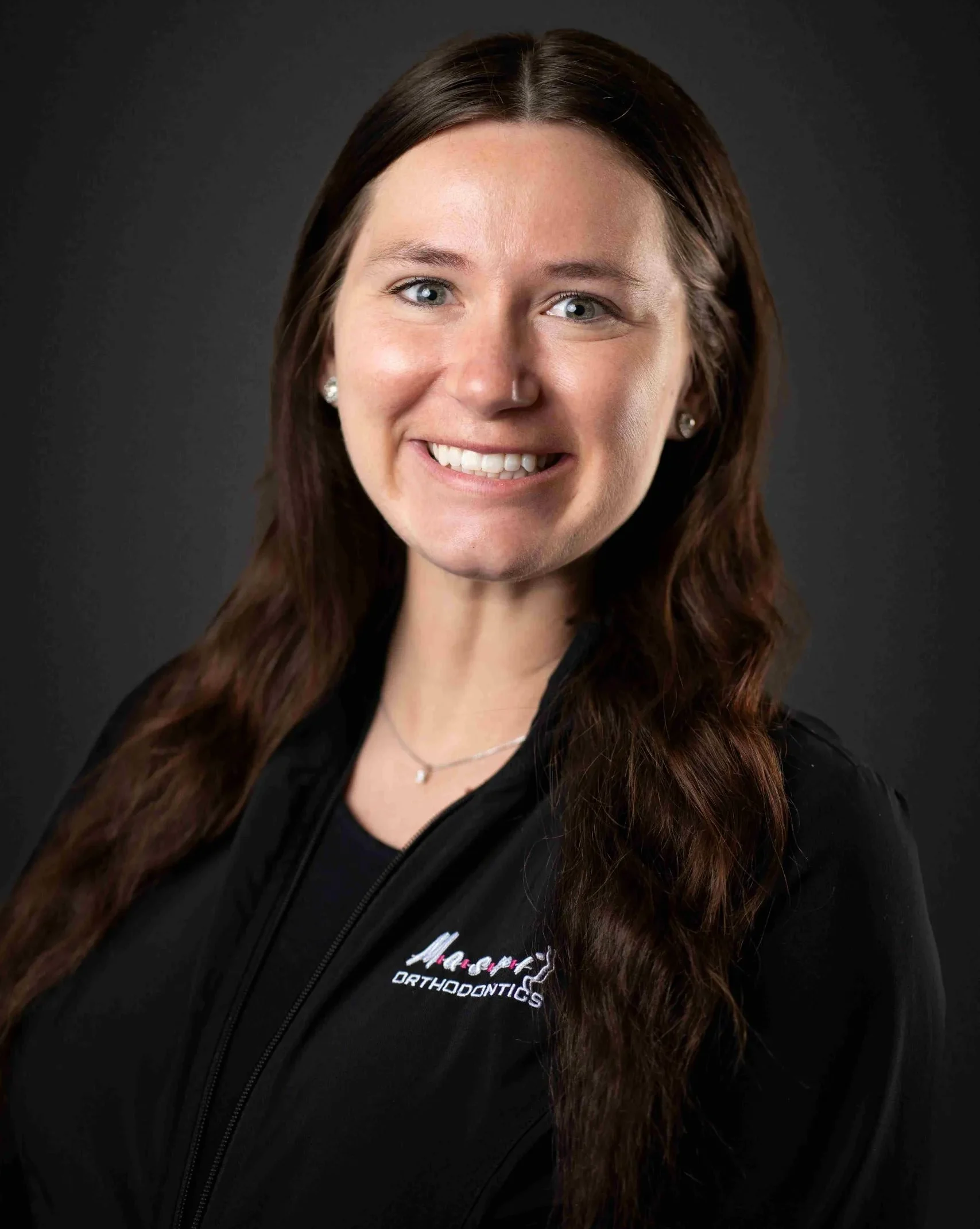 Masri Orthodontics team member, Christy, smiling and wearing a professional jacket.