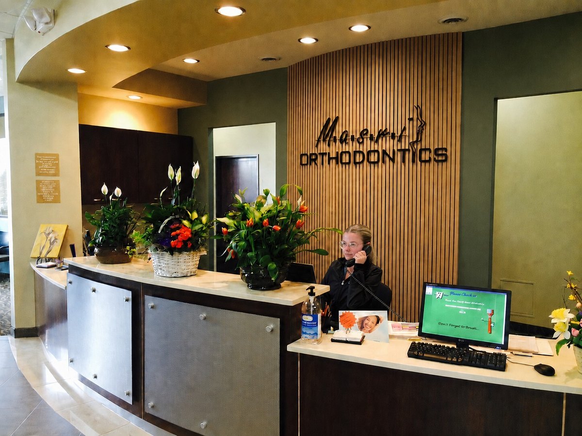 Masri Orthodontics reception desk with a team member answering the phone.